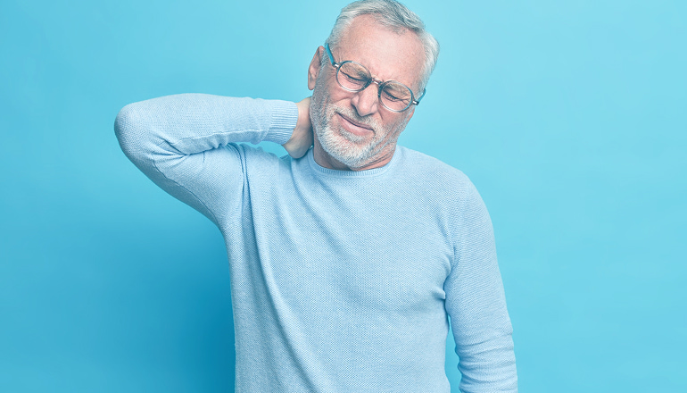 hombre con la mano en el cuello por cervicalgia, una secuela después de un accidente de trafico